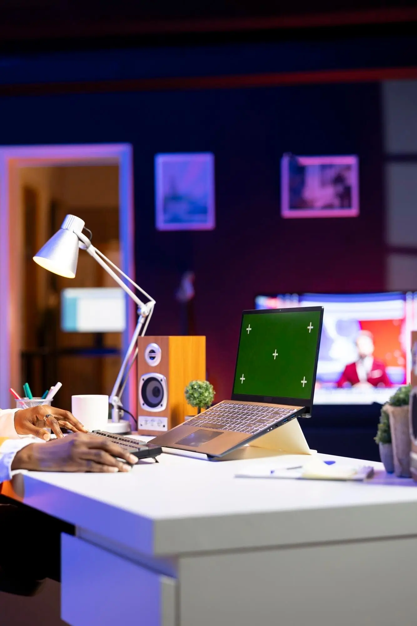 Person am Homeoffice-Schreibtisch, die einen Laptop mit Greenscreen-Mockup verwendet.