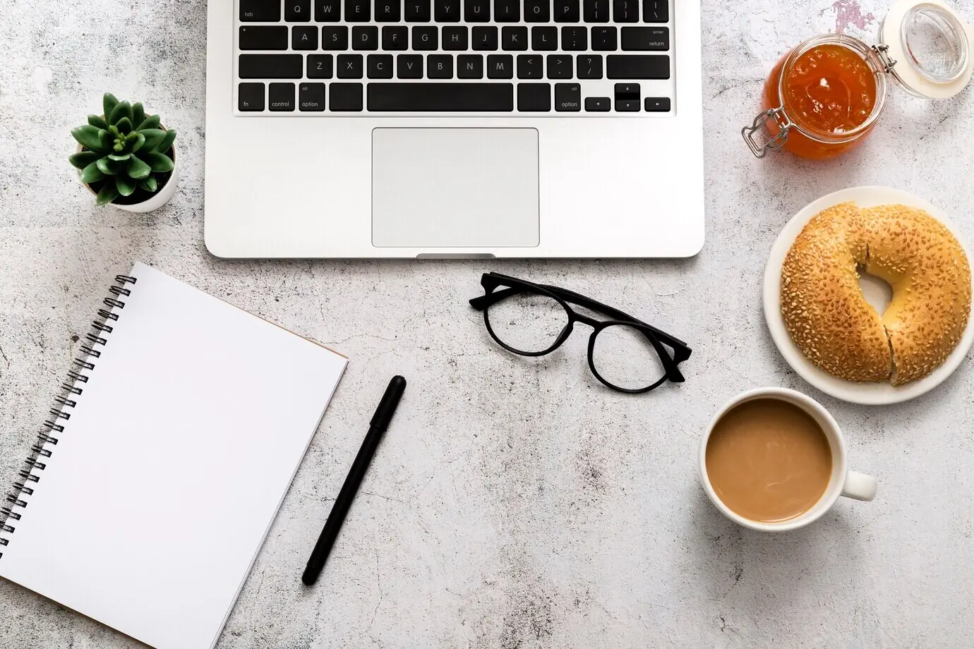 Draufsicht auf einen Bagel mit Kaffee auf dem Tisch.